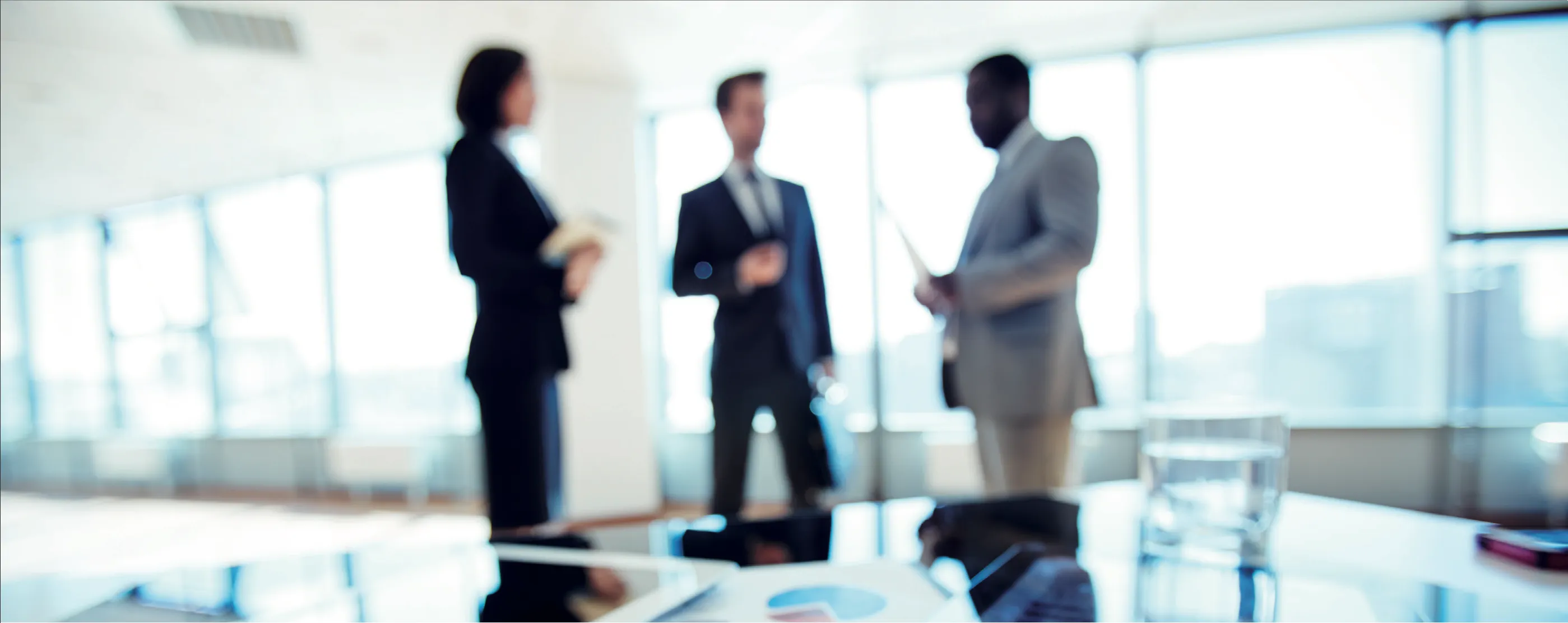 Equipo profesional conversando en una sala de reuniones corporativa